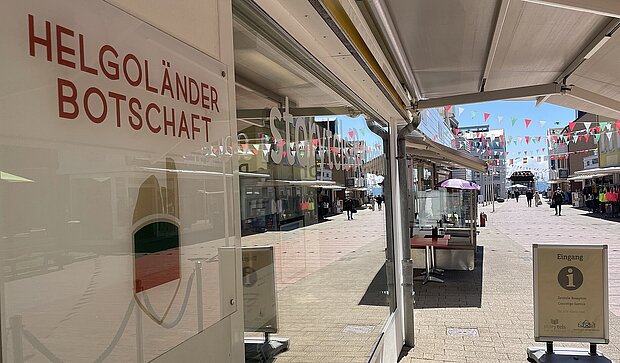 Ein Schild mit "Helgoländer Botschaft", daneben die Strasse Lungwai auf Helgoland 