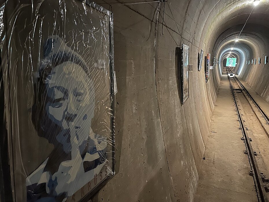 Ein Bild, welches James Krüss darstellt, aufgehängt in einem Tunnel